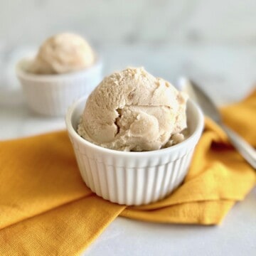 Scoops of homemade banana ice cream in white bowls.