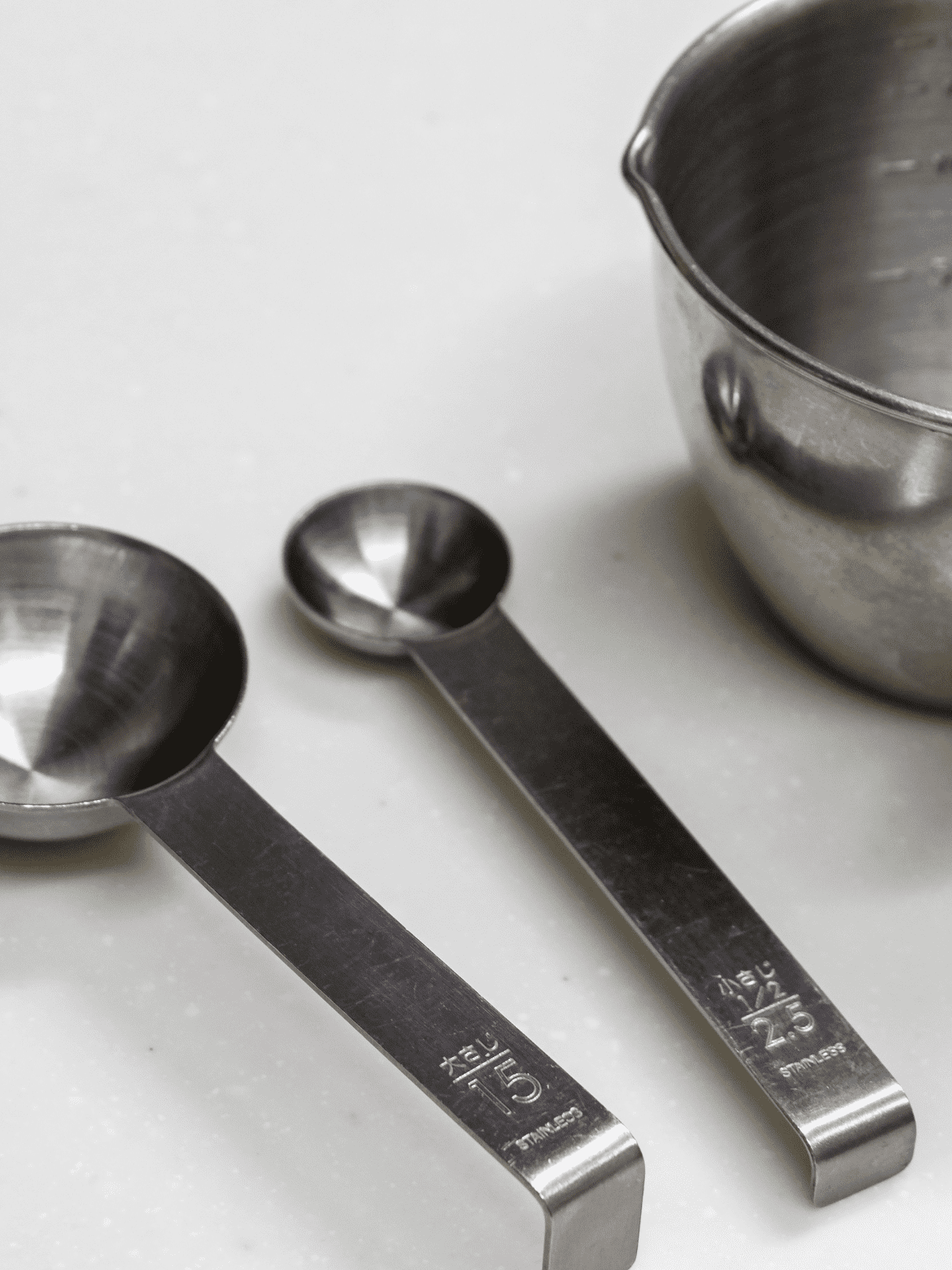 Metal measuring spoons and cup.