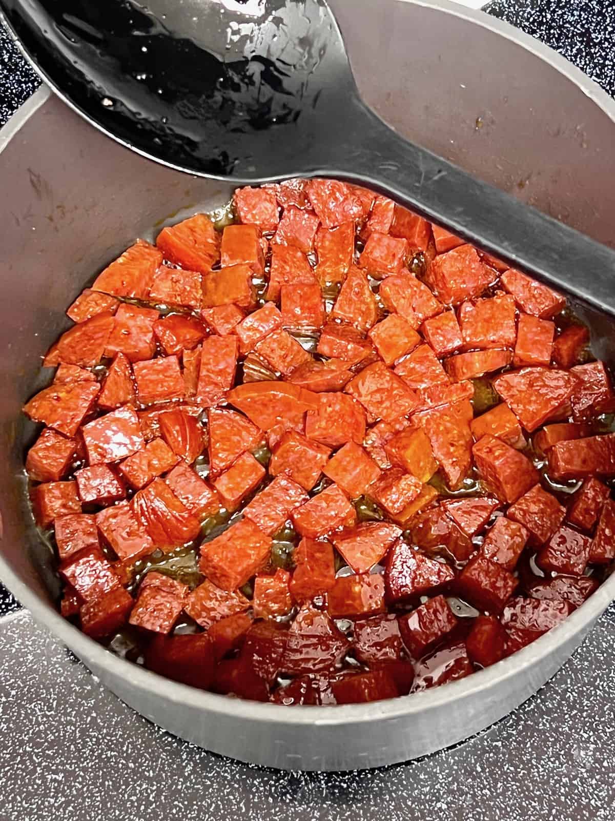 Pepperoni chunks cooking in the pot.