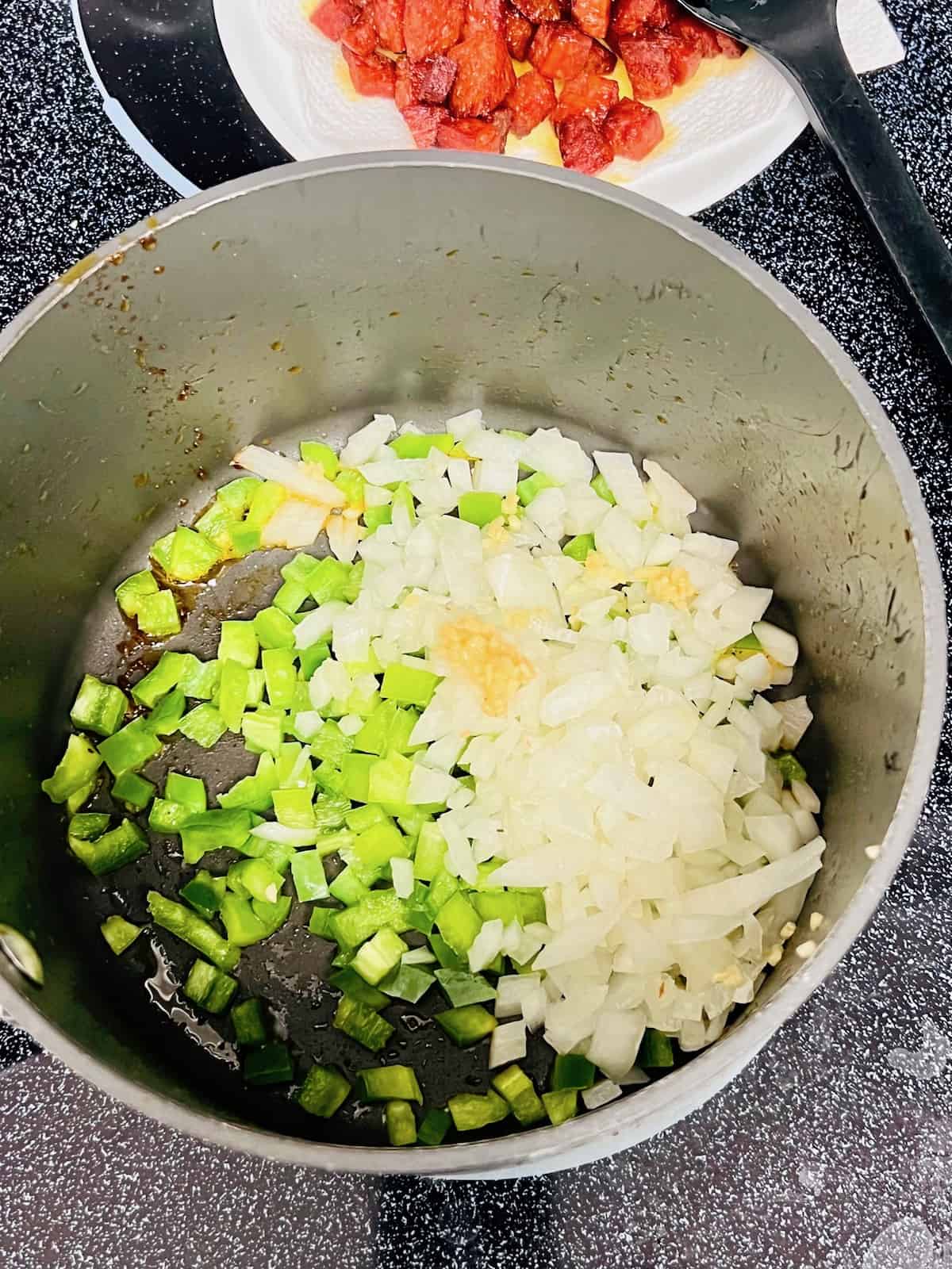 Vegetables cooking in the pot with the pepperoni drippings.