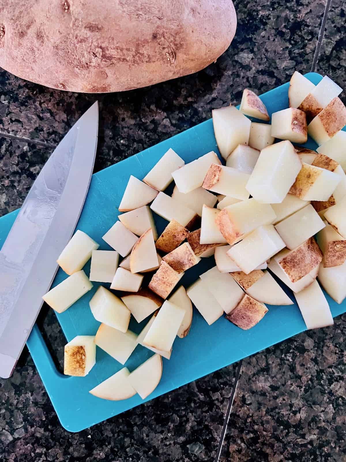 Cut cubes of potato on a cutting board.