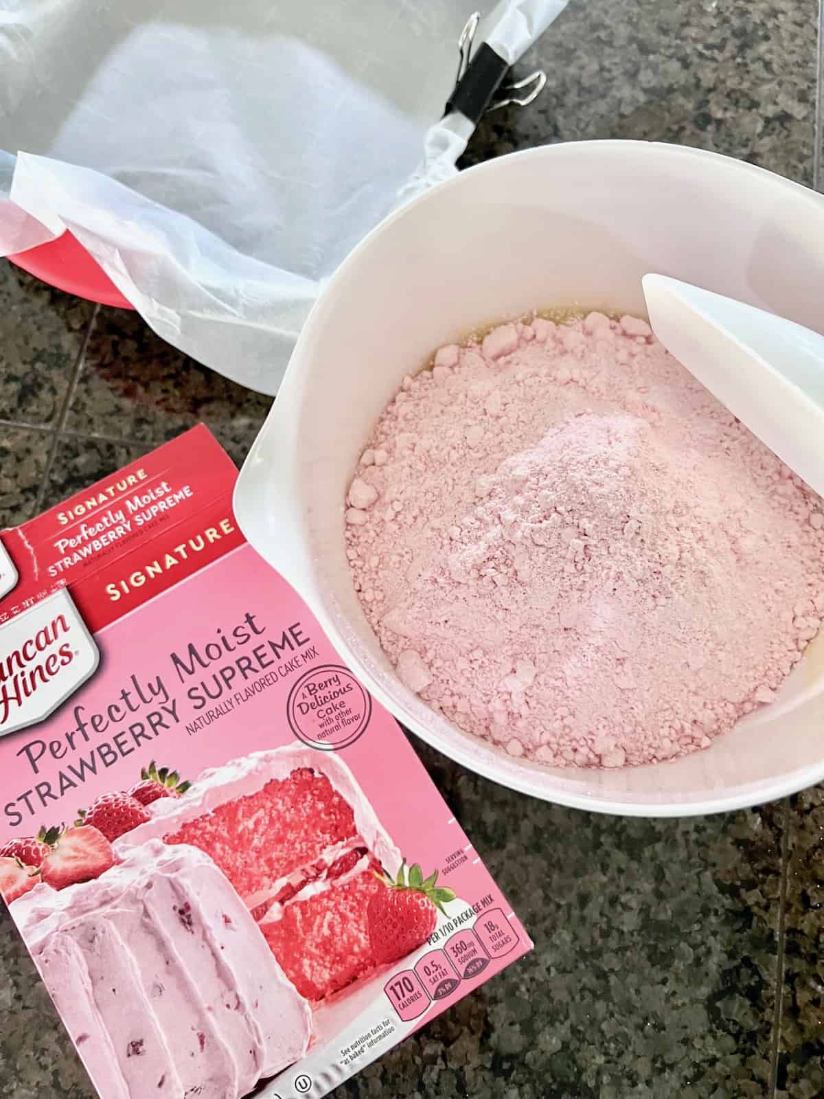 Adding cake mix to bowl.