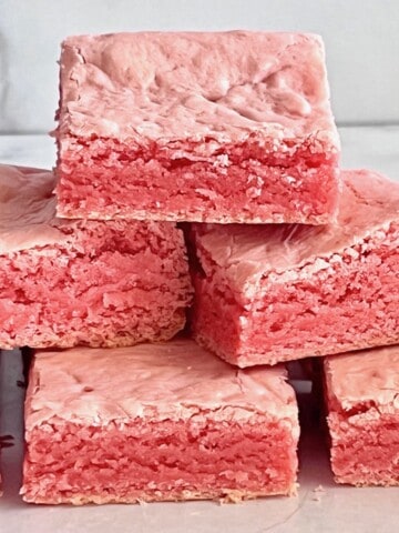 Stacked strawberry brownies on the counter.