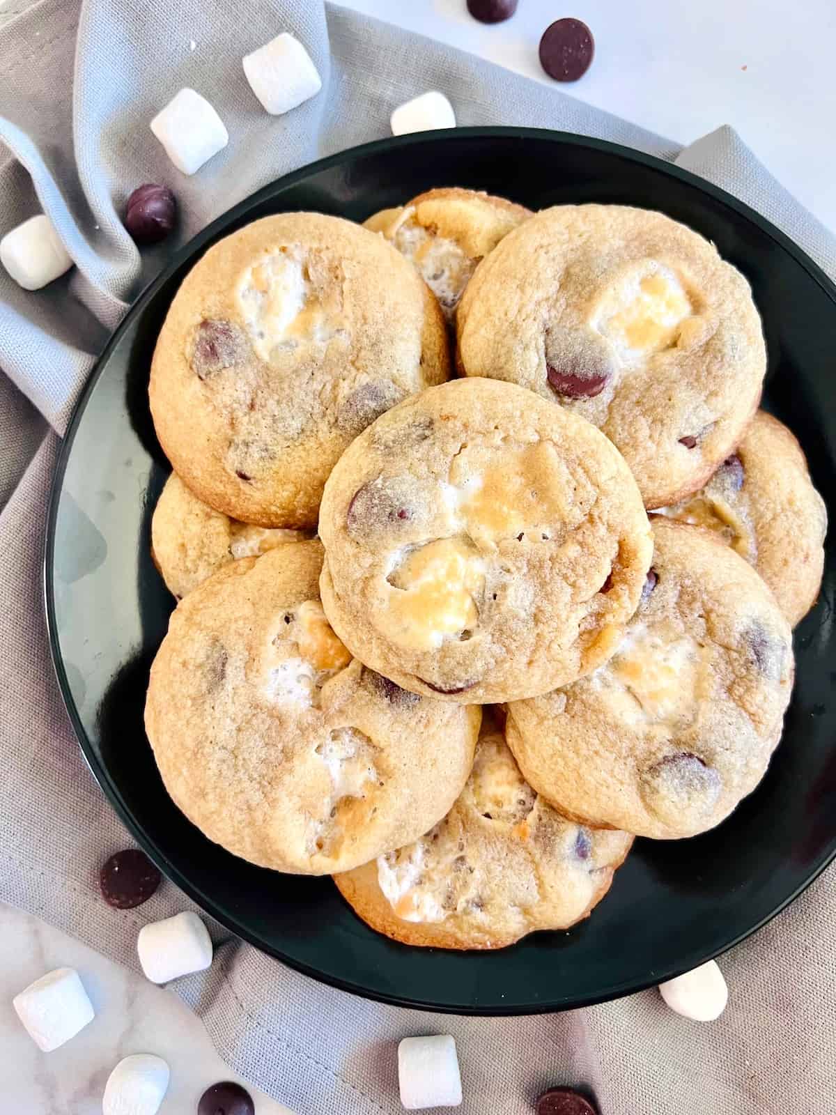 Chocolate Chip Marshmallow Cookies Plated with blue napkin and sprinkling of chips and mini marshmallows.