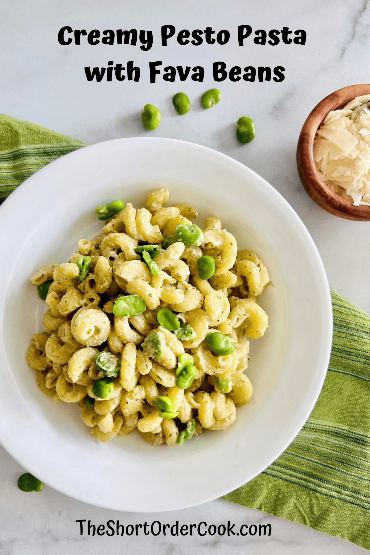 White bowl filled with creamy pesto sauces tossed with cavatappi pasta and fava beans.
