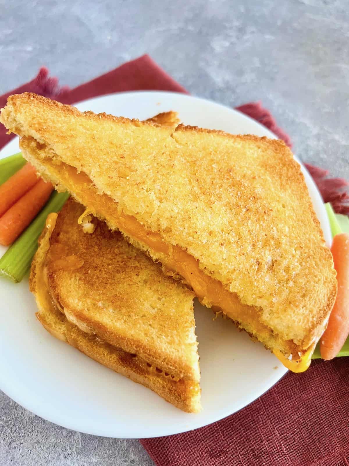 Microwave Grilled Cheese Plated & ready to eat with carrots and celery.