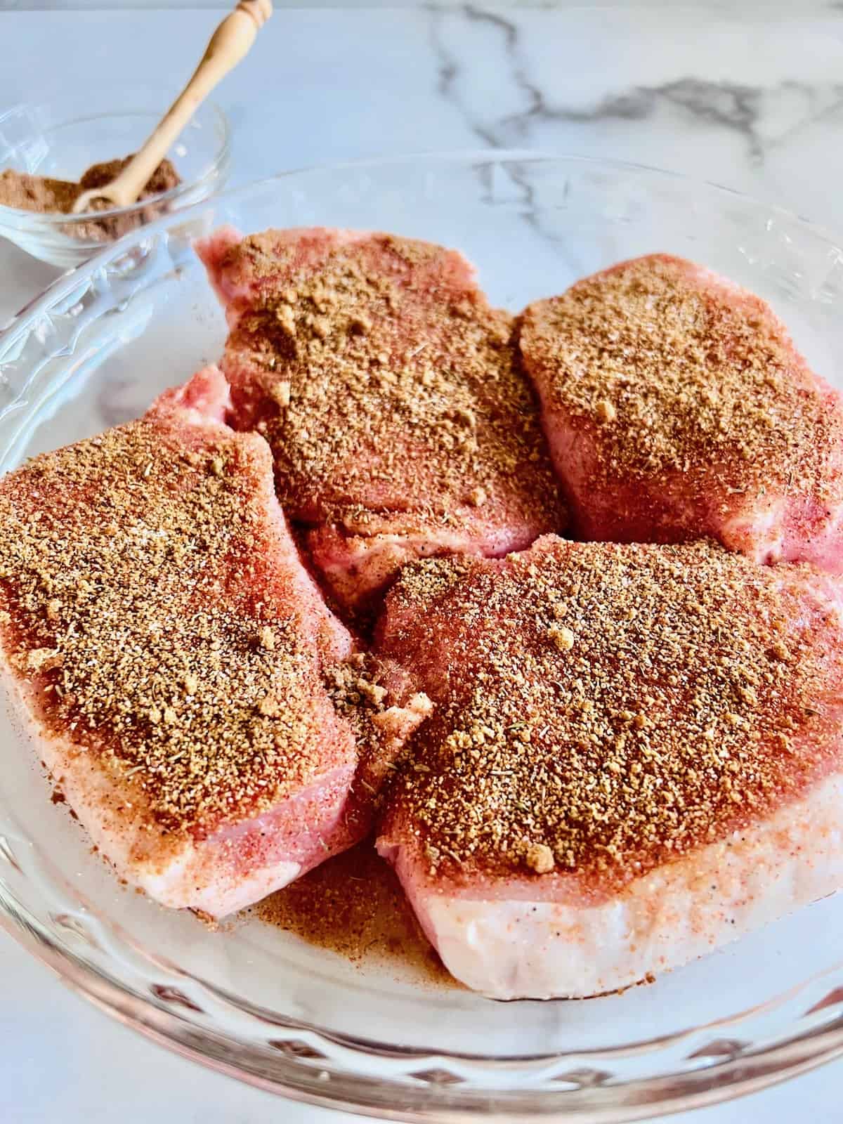 4 chops in a dish with a dry rub applied to all surfaces.
