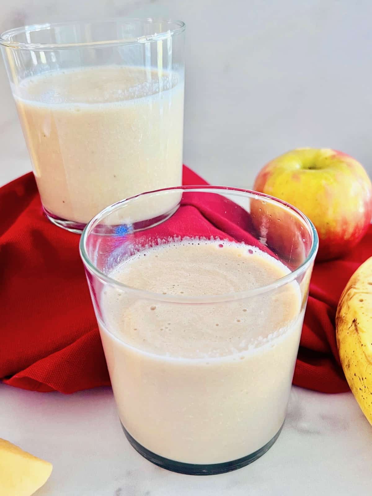Smoothies made from apple and banana with milk poured into glasses to drink.