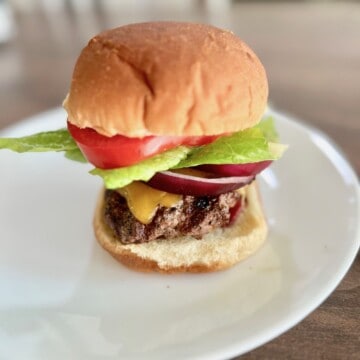 Grilled Wagyu beef Burger on a bun with toppings plated and ready to eat.