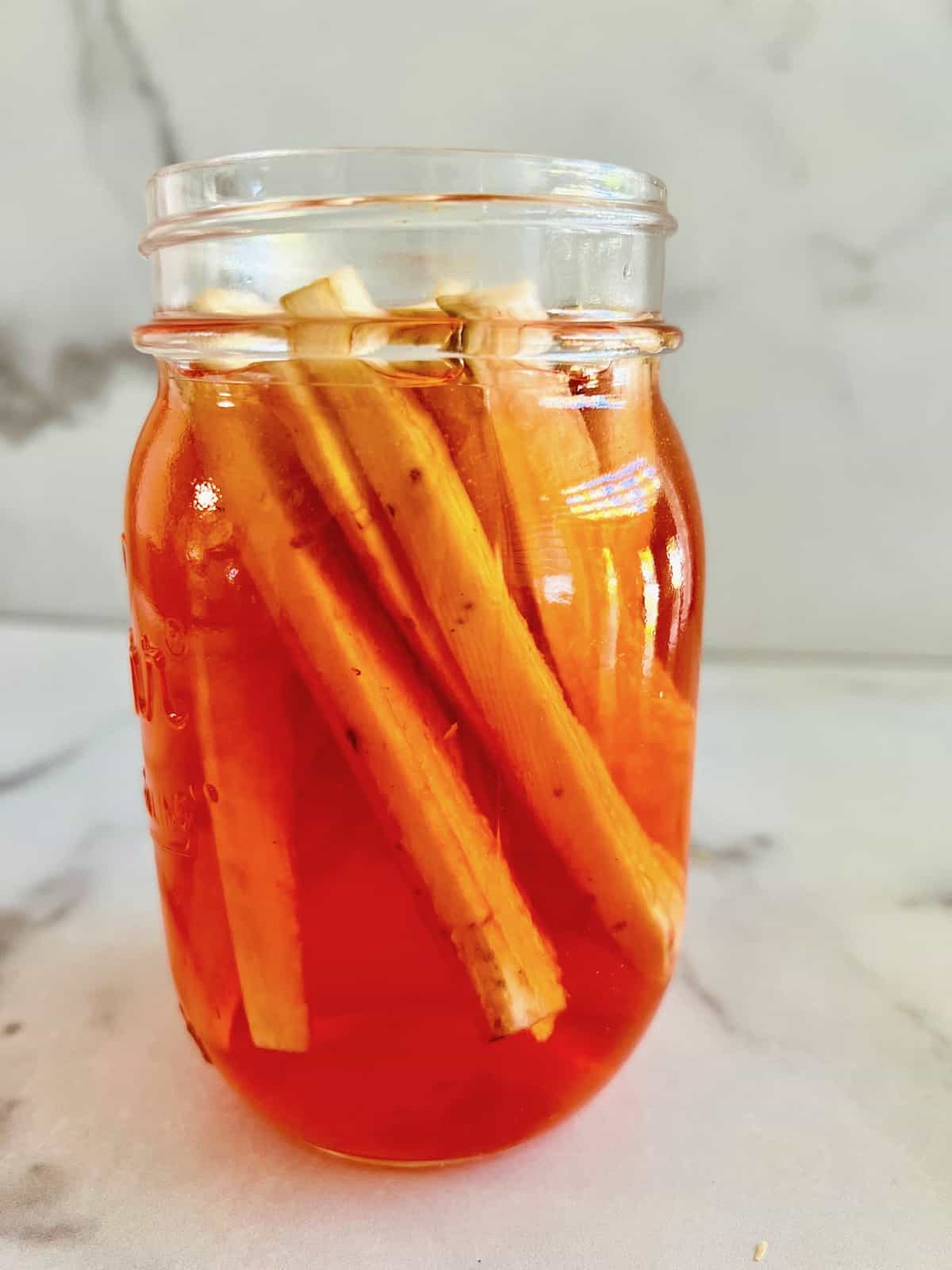 Burdock root and orange pickling liquid in the mason jar