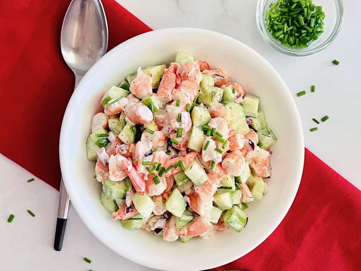 Bowl of diced cucumber salad with shrimp & dill dressing.