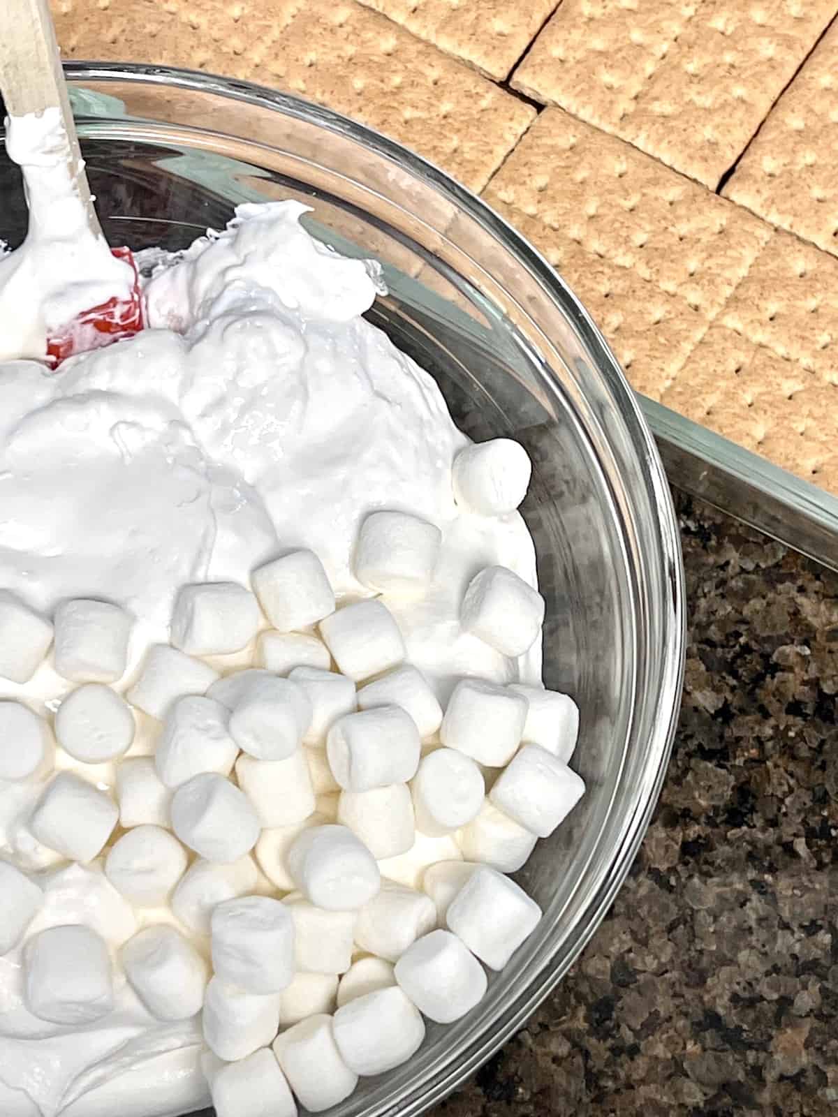 Folding together the marshmallow and coolwhip.