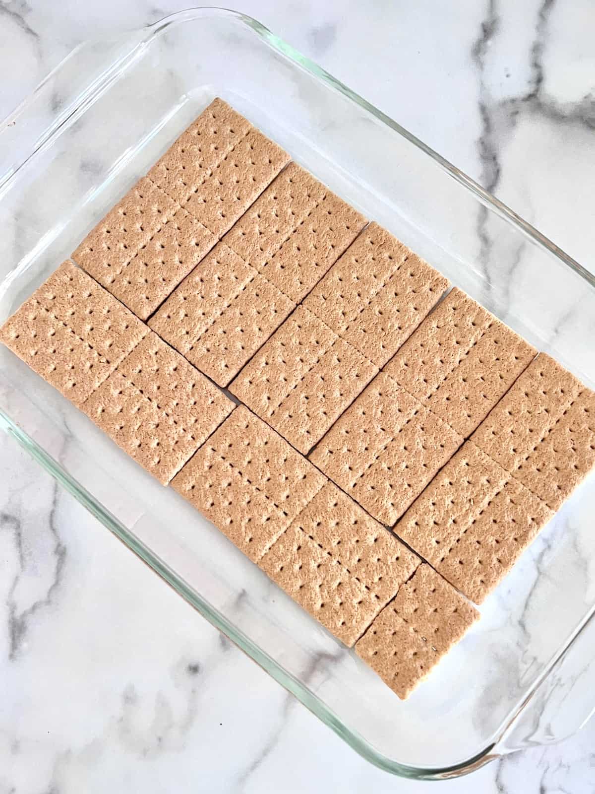Graham crackers lined up to cover the bottom of 9x13 pan.
