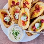 Air Fryer Loaded Potato Skins Featured plated stuffed bacon cheddar potato skins with sour cream dip.