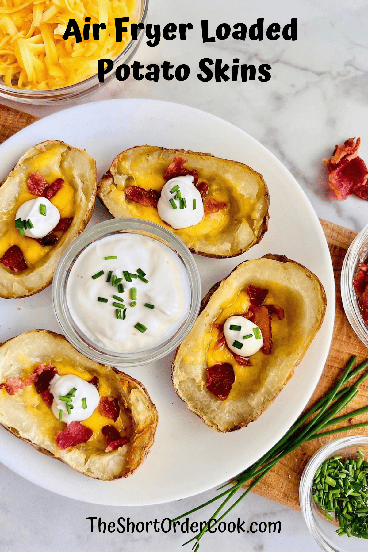 Air Fryer Loaded Potato Skins plated and filled with melted shredded cheddar crispy bacon & sour cream chive dip.