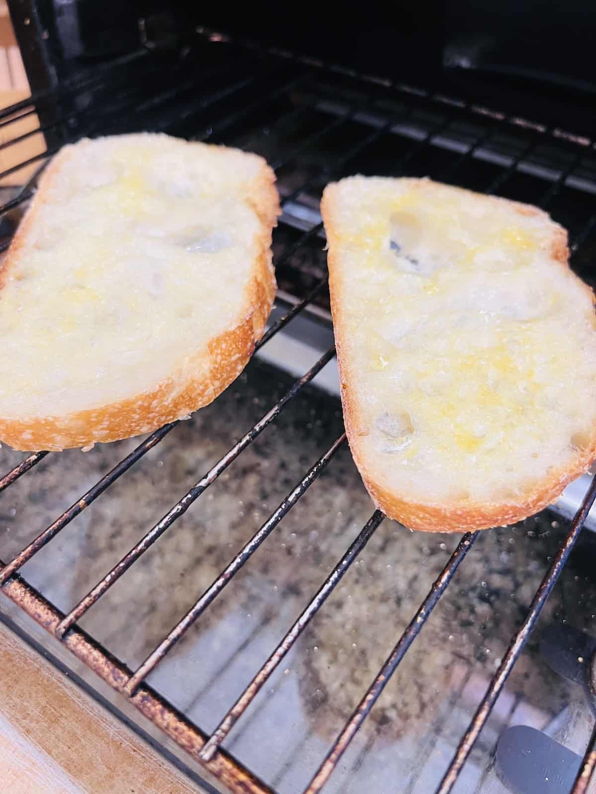 d slices topped with olive oil and garlic in a toaster oven.
