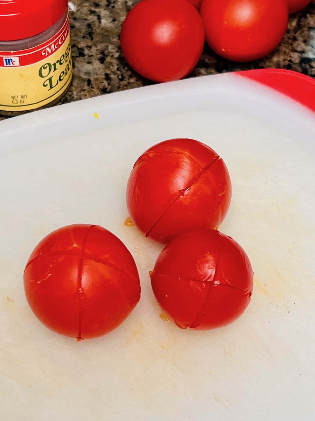 Fresh tomatoes with x cuts in the outer skin.