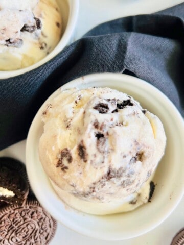 Oreo Cookies & Cream Ice Cream Overhead ramekins filled with scoops next to black linen napkin and sandwich cookies