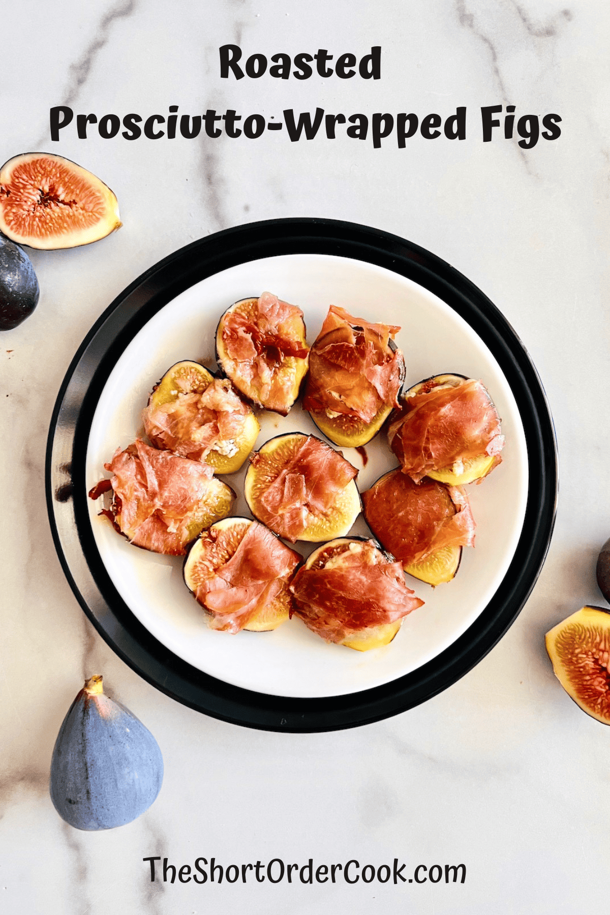 Plated roasted figs wrapped in prosciutto next to fresh figs on the counter.