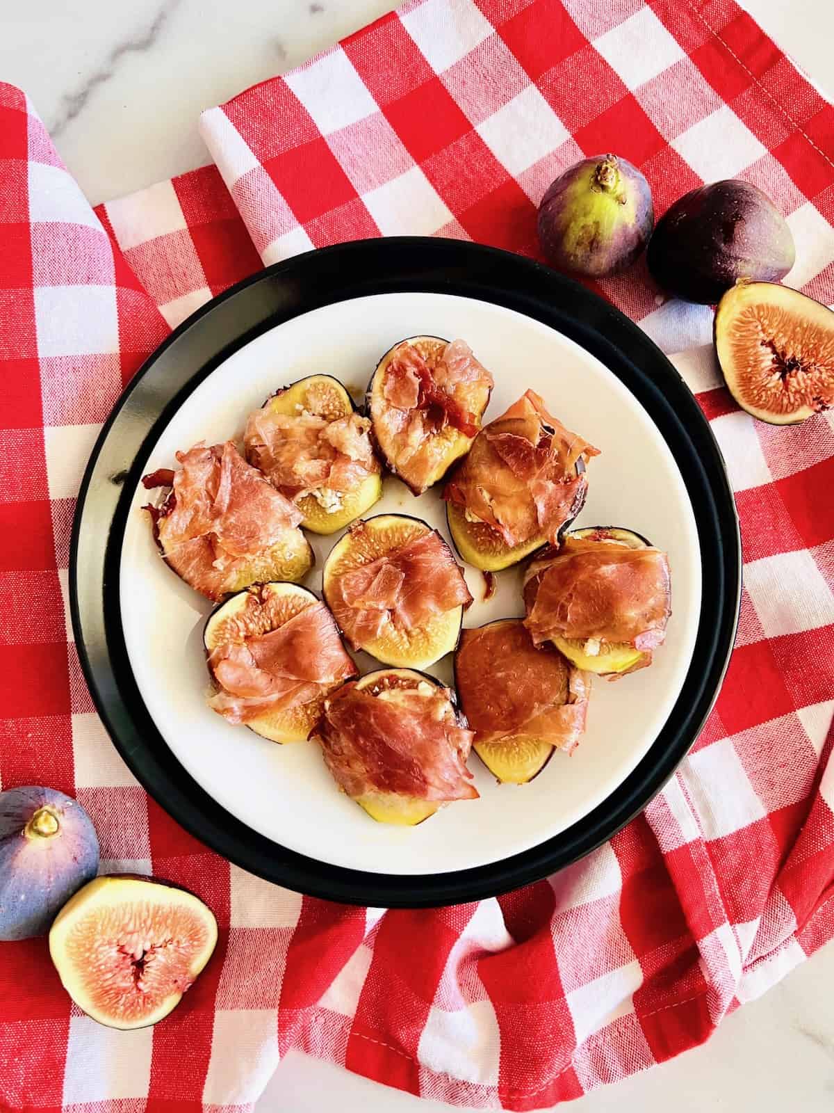 Roasted Prosciutto-Wrapped Figs Plated with figs and red checkerboard napkin.