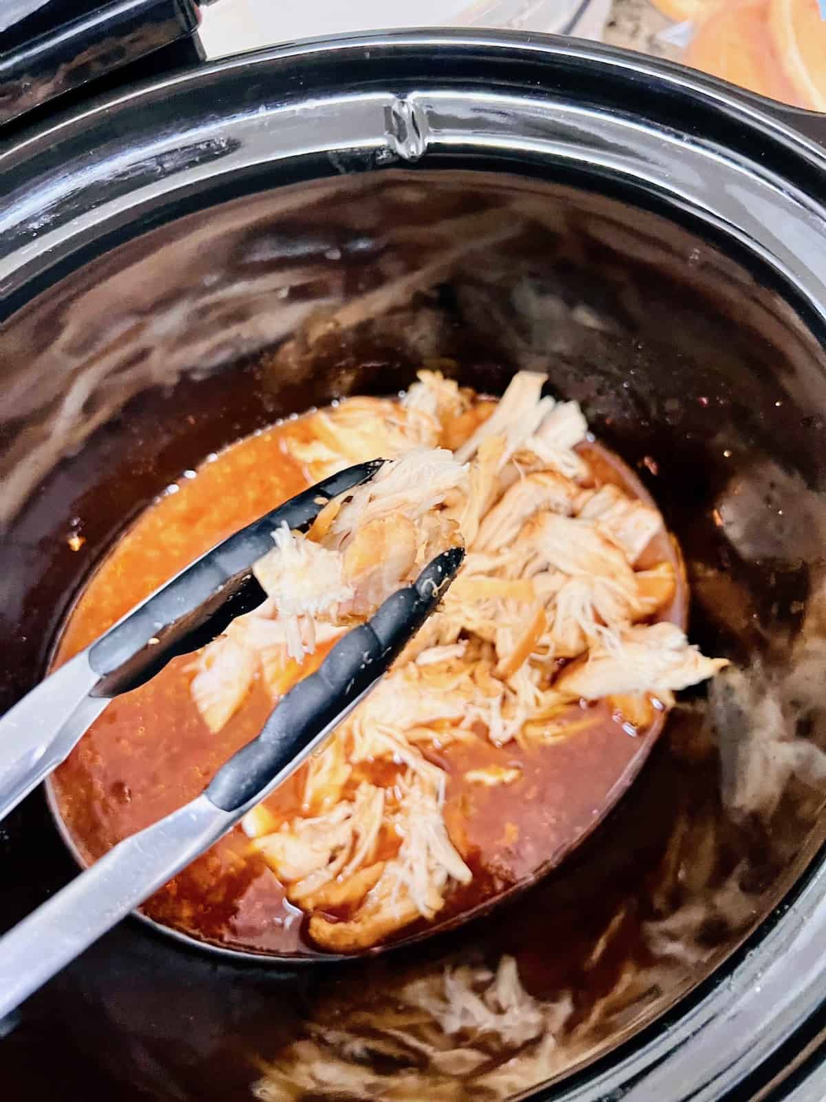 Slow Cooker BBQ Pulled Chicken Adding shredded chicken back into the slow cooker with bbq sauce and vinegar.