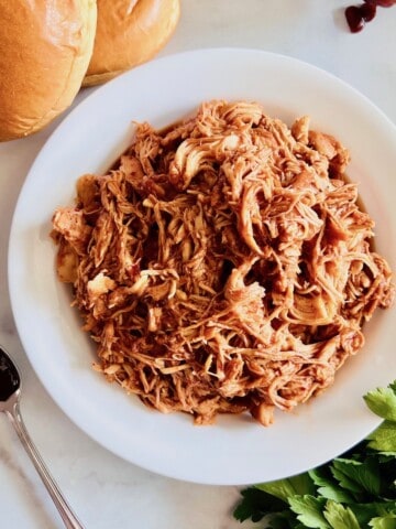 Slow Cooker BBQ Pulled Chicken in a bowl ready to serve with bbq sauce.