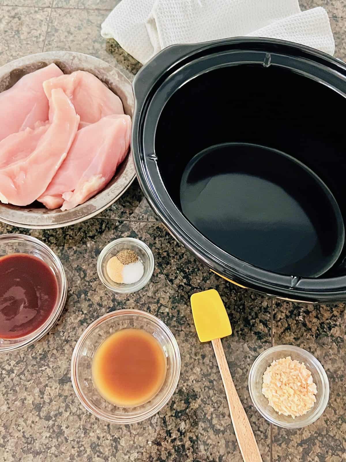 Slow Cooker BBQ Pulled Chicken Ingredients next to insert for CrockPot.