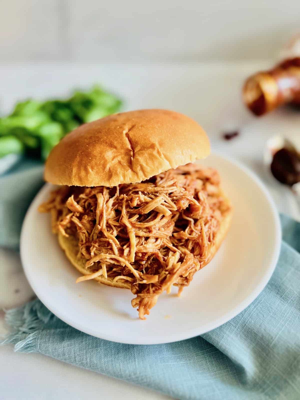 Slow Cooker BBQ Pulled Chicken Portrait on a bun.