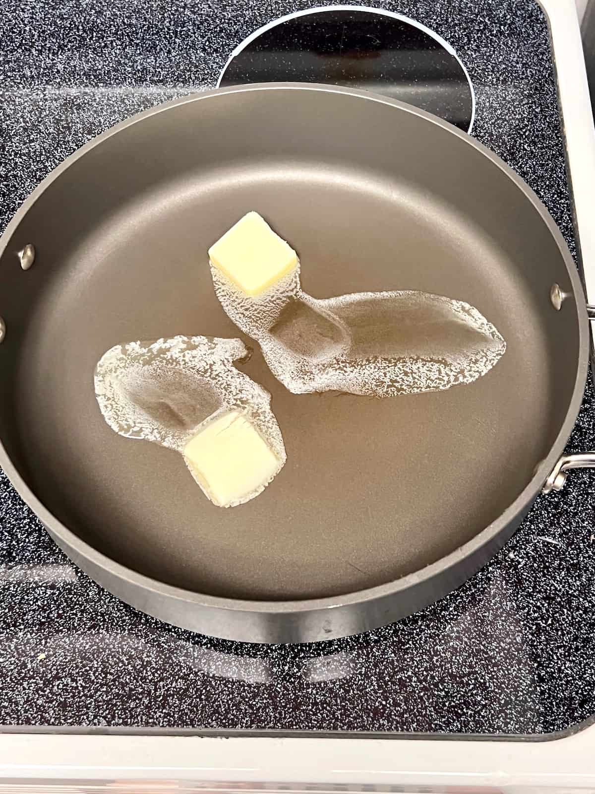 Melting butter in the skillet.