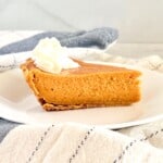 Graham Cracker Crust Sweet Potato Pie Slice plated with dollop of whipped cream