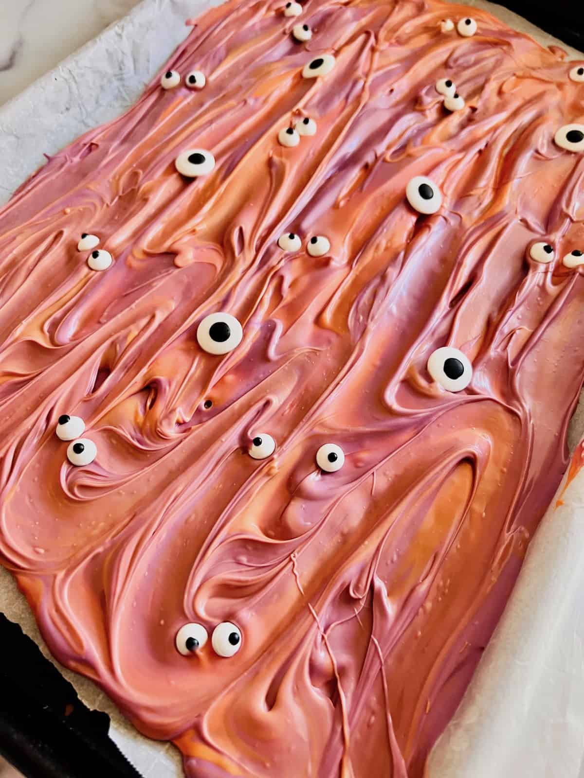 Orange and purple melted candy topped with candy eyeballs.