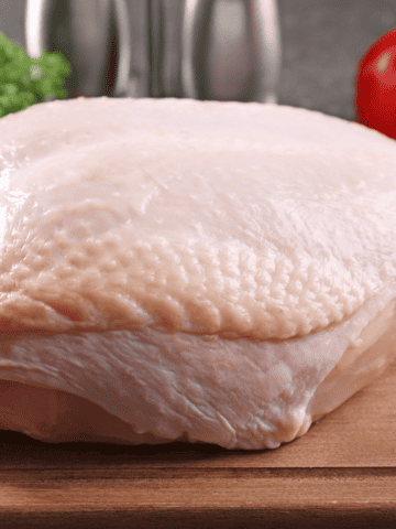Raw turkey breast with the skin on.