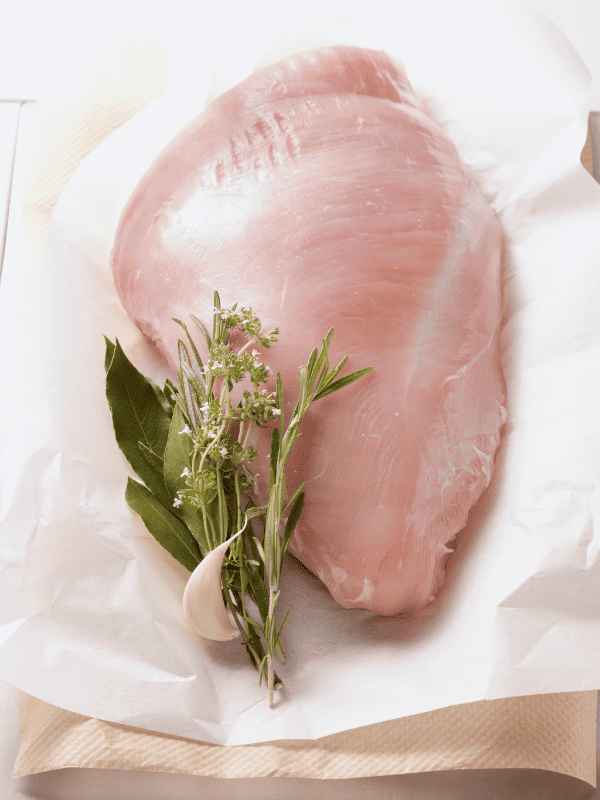 Raw turkey breast with spices and herbs.