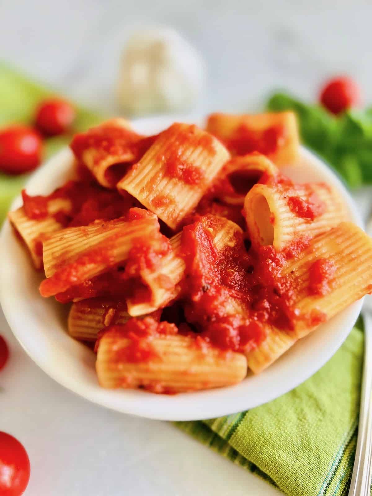 Bowl filled with rigatoni pasta in a red sauce. 