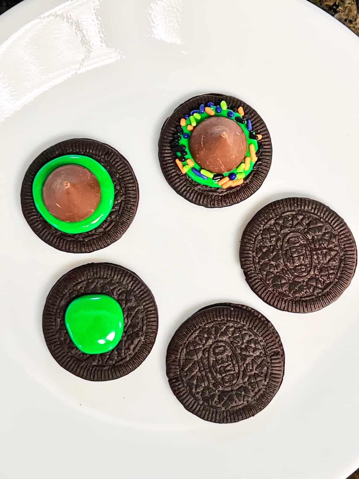 5 Oreo cookies on a plate each topped differently.