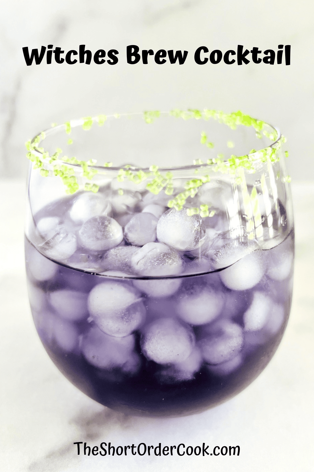 Round glass with round small ice cubes and purple cocktail.