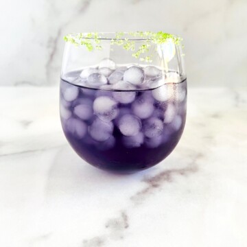 Purple Halloween Witches Brew Cocktail in a round glass.