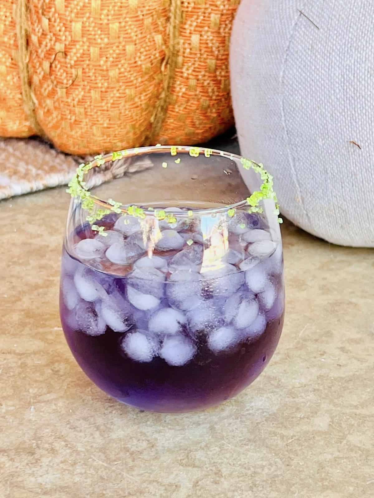 Witches Brew Cocktail next to decorative pumpkins.