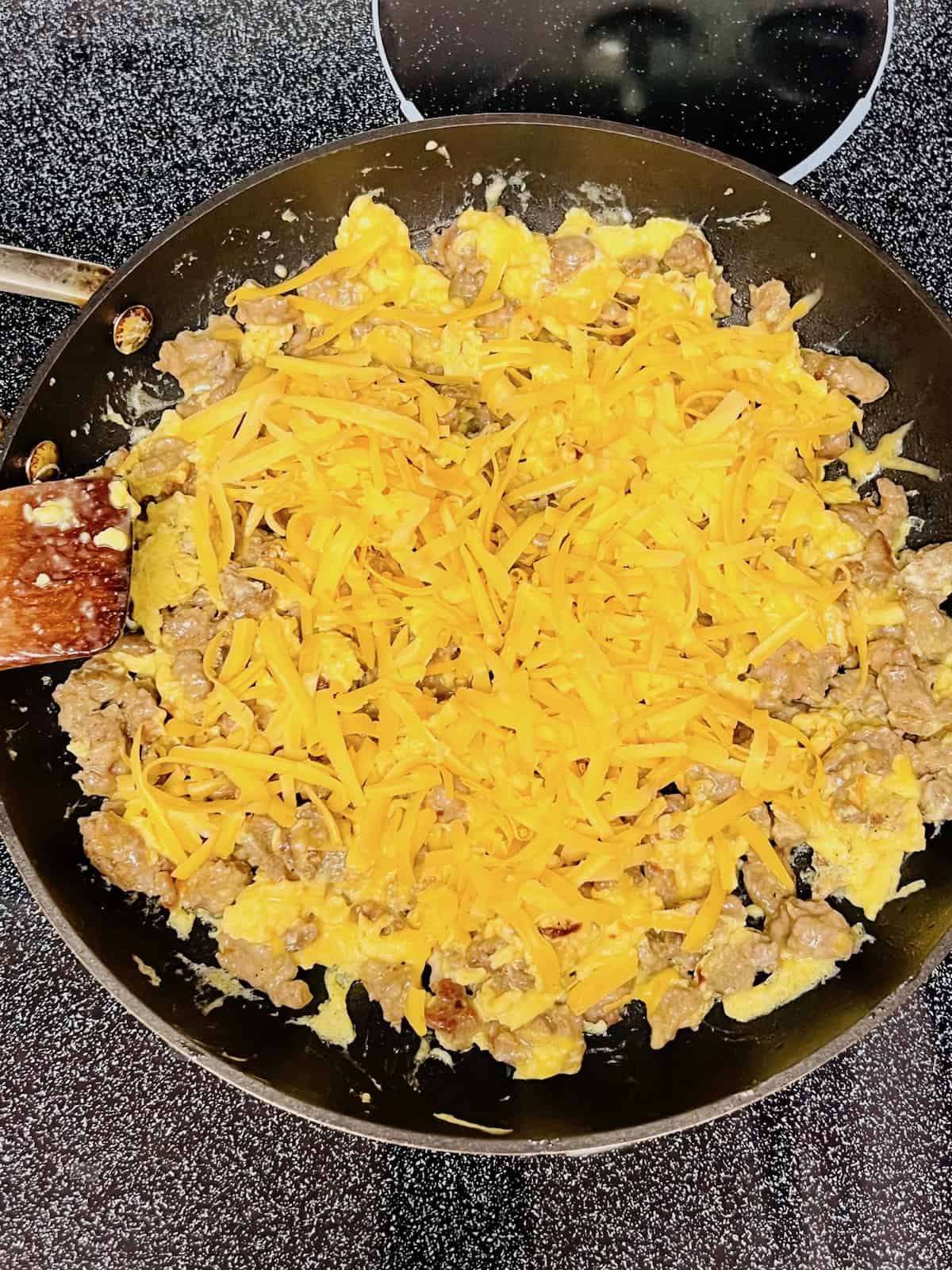 Breakfast Sausage, Egg, & Cheese Scramble Adding cheese to the top.