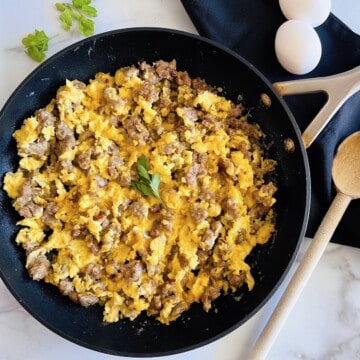 SKillet cooked scrambed eggs with crumbled breakfast sausage and cheddar cheese.