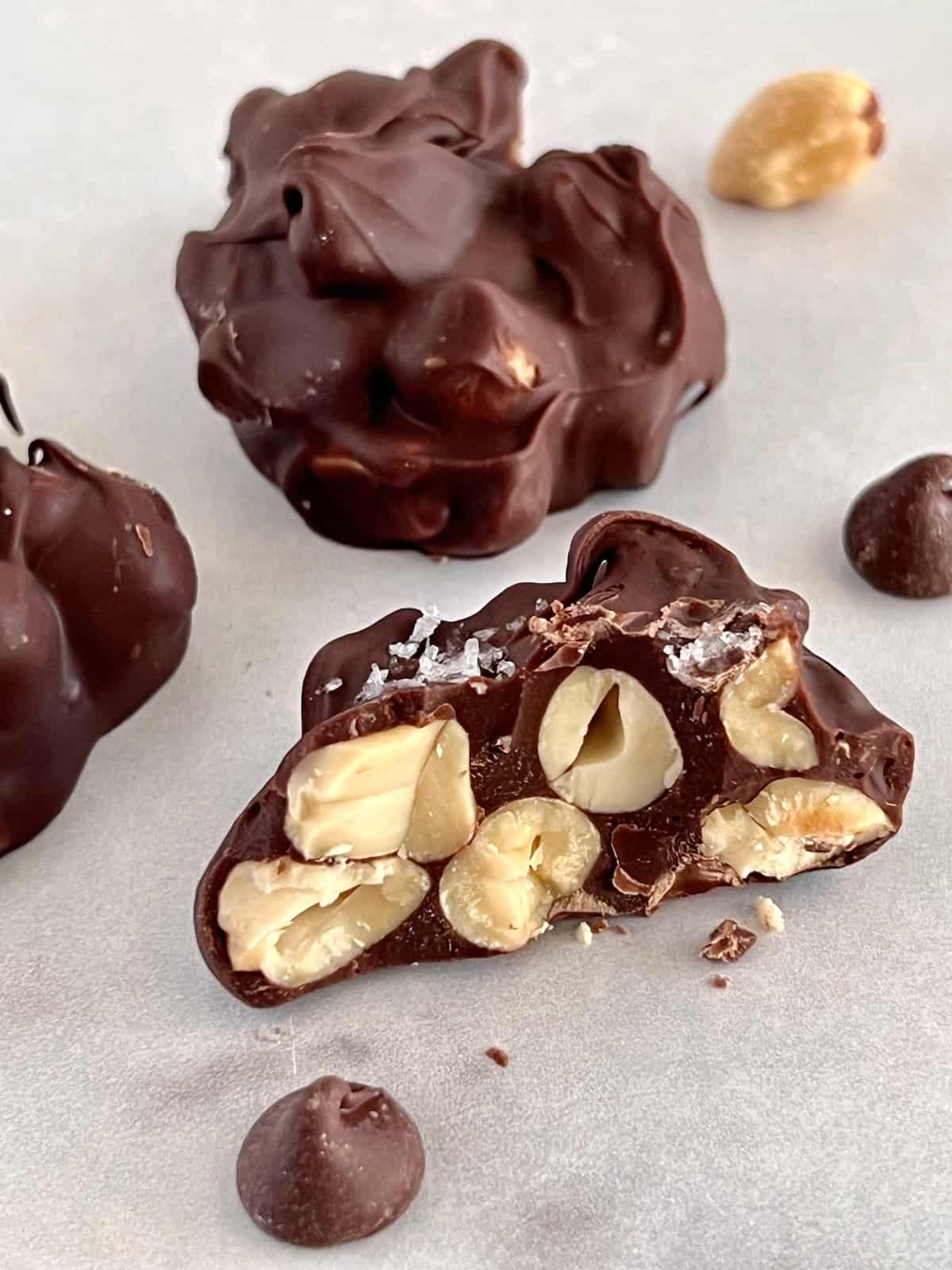 Chocolate Peanut Clusters Bitten into showing peanuts inside the chocolate covering