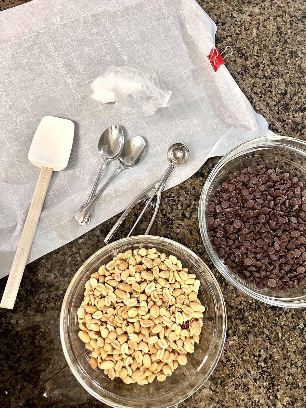Bowls and utensils needed to make chocolate and peanut cluster candies. 
