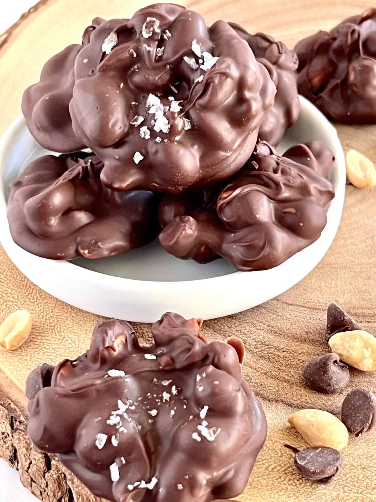 Chocolate Peanut Clusters stacked on a plate.