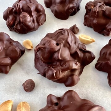 Chocolate Peanut clusters next to peanutes.