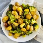 Serving plate piled high with roasted potato chunks and broccoli florets.