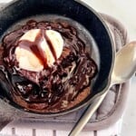 Cast iron skillet with sizzling hot fudge brownie and vanilla ice cream.