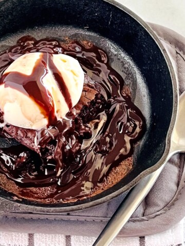 Cast iron skillet with sizzling hot fudge brownie and vanilla ice cream.