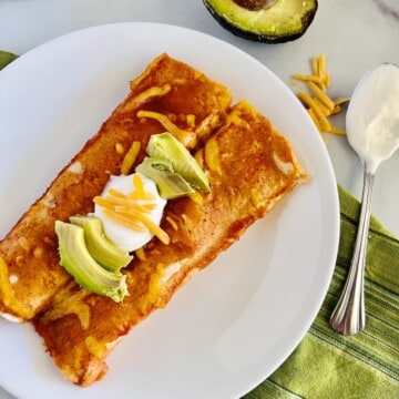 Plate of two potato cheddar cheese enchiladas.