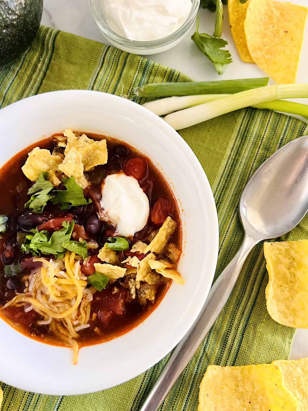Easy Black Bean Enchilada Soup Best homemade recipe in a bowl topped with chips cheese and sour cream.