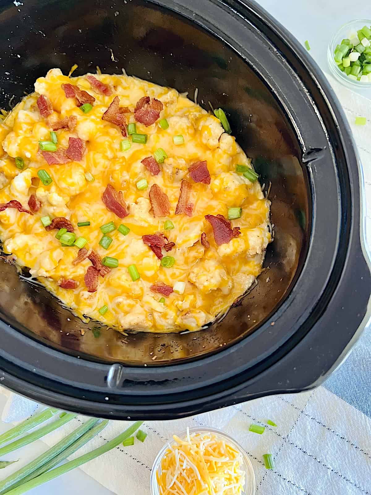 Slow Cooker Loaded Chicken & Cauliflower Casserole Best Recipe topped with cheese bacon and green onion in Crockpot.